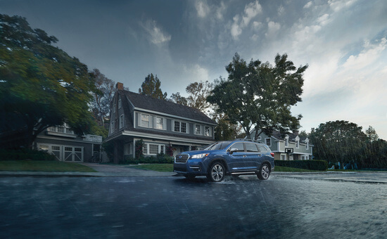A blue Subaru Ascent outside a house