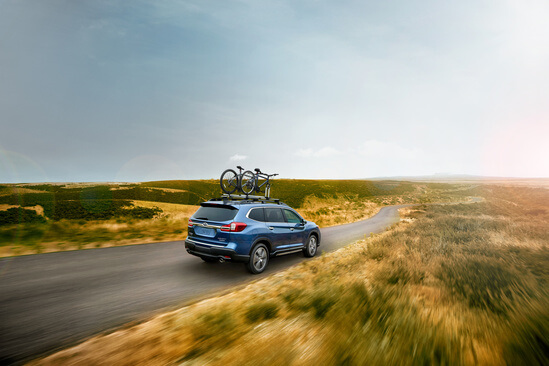 A blue Subaru SUV driving in the country