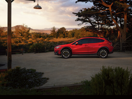 A red Subaru Crosstrek at sunset