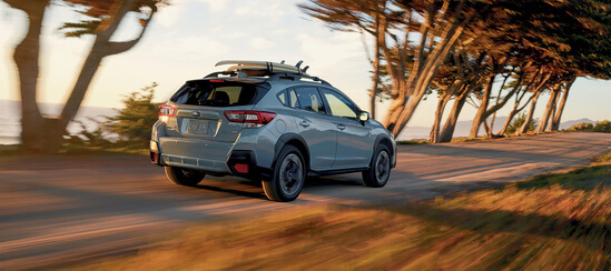 A Subaru Crosstrek driving near trees