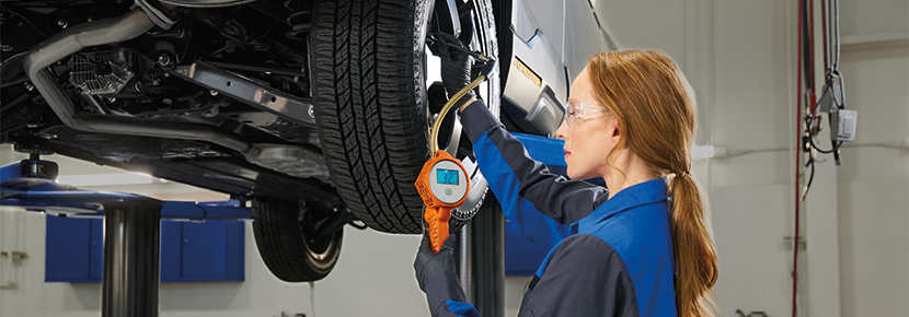 A Subaru technician checking tire pressure. | Fitzgerald Subaru of Gaithersburg in Gaithersburg MD