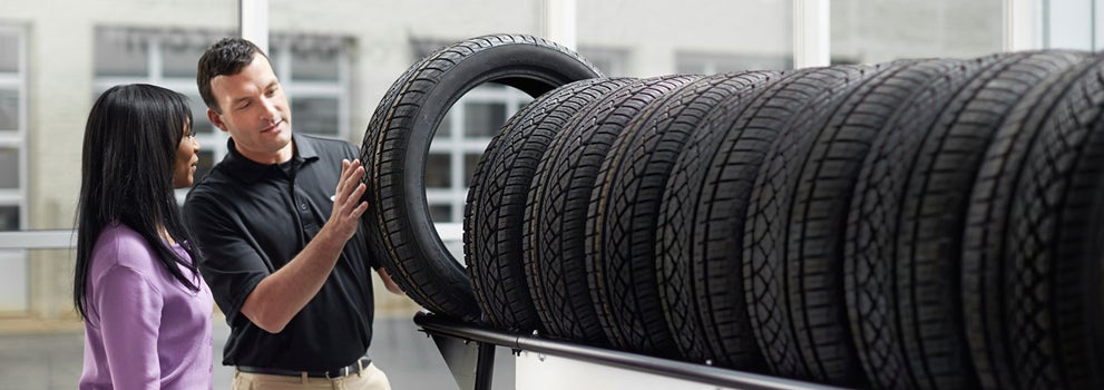 Subaru service representative showing customer a tire. | Fitzgerald Subaru of Gaithersburg in Gaithersburg MD
