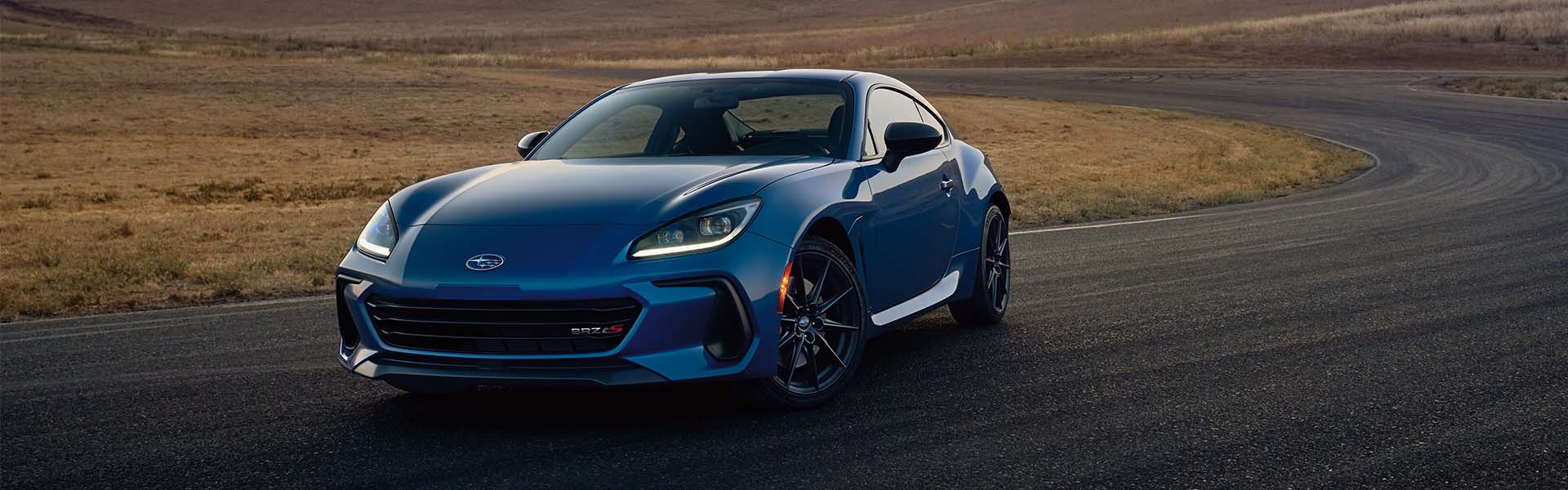 Blue Subaru BRZ sports coupe on a winding road.